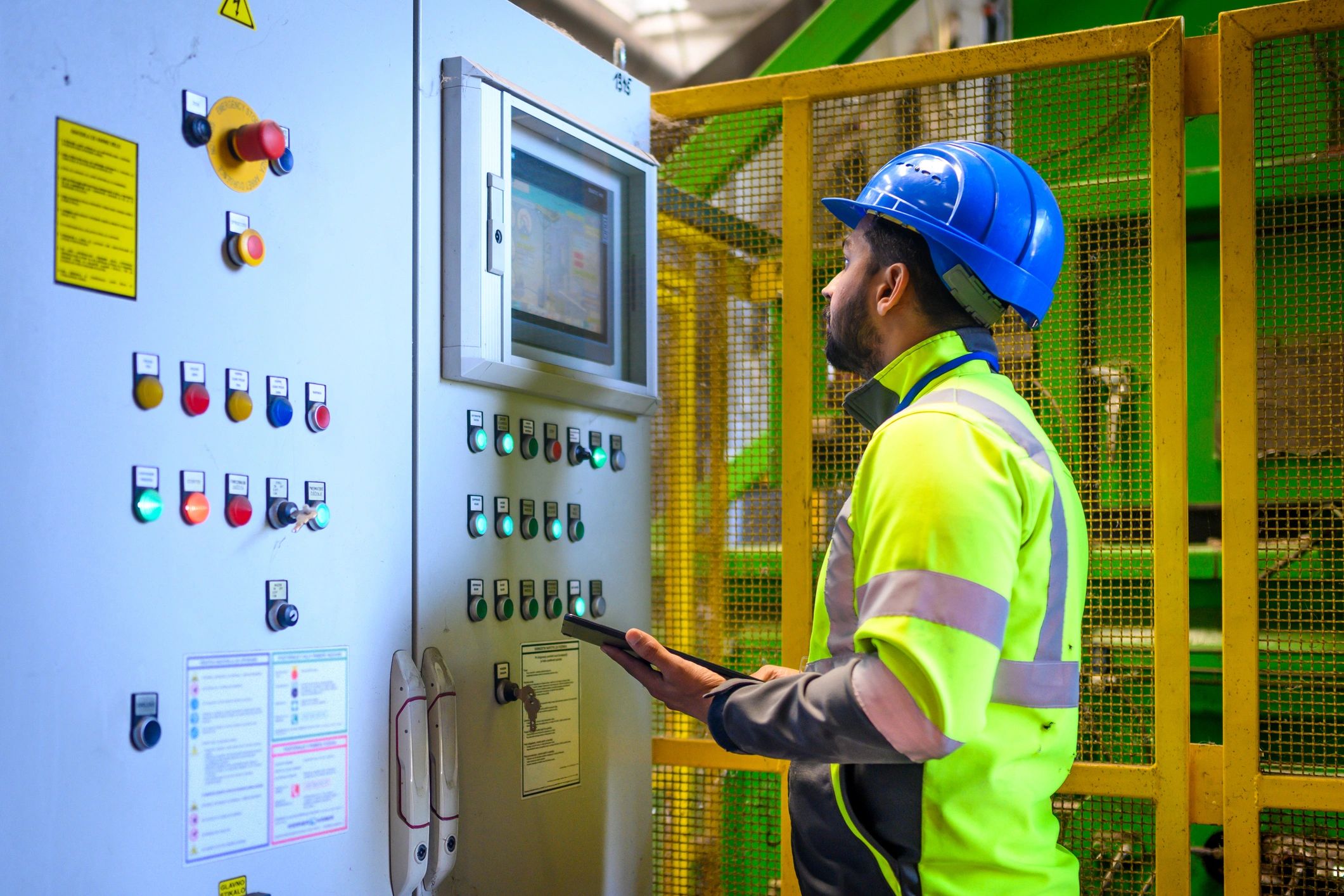 Technician supervising industrial operations with a tablet